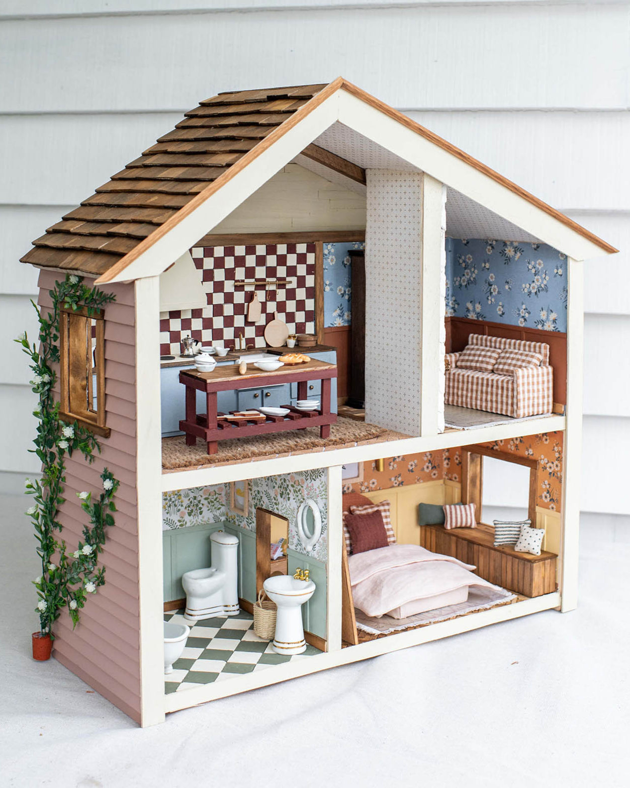 Detailed dollhouse with various rooms on a white background