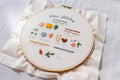 Embroidery hoop with basic stitches diagram on a light fabric background