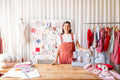 Woman in a sewing studio with a sewing machine and fabric on a table.